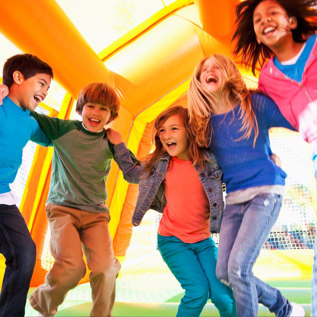 a group of children playing in a bounce house